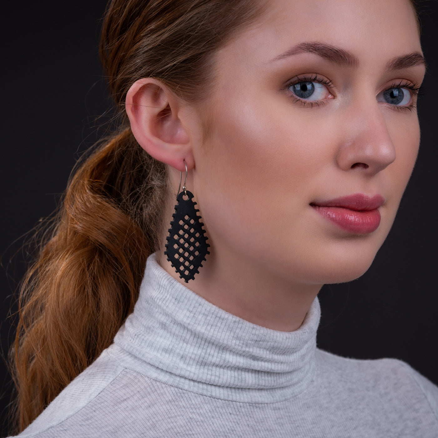 Stylish Paguro Upcycle recycled rubber earrings with a unique design, worn by a model