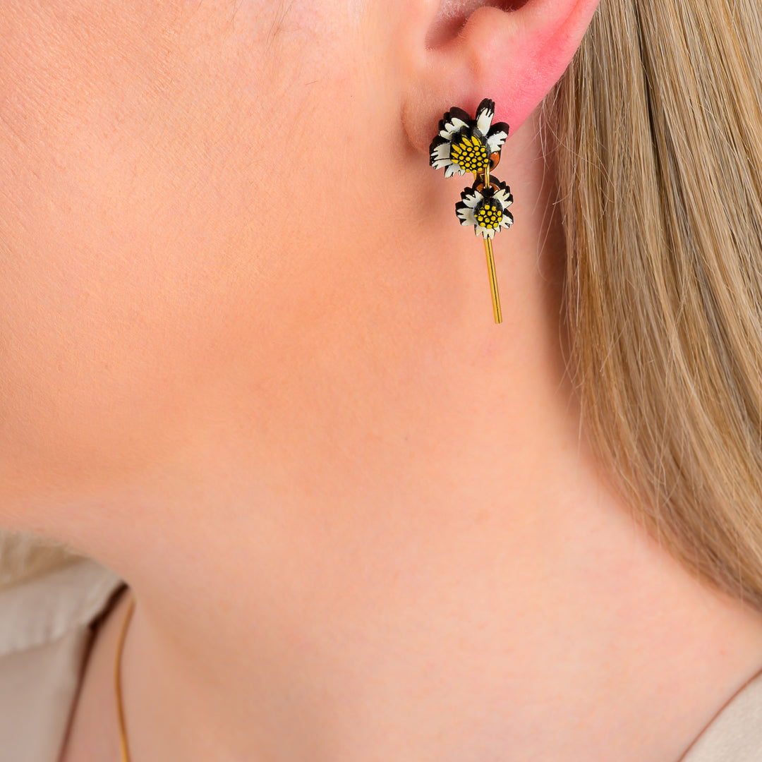 Paguro Upcycle reclaimed wood earrings with black and white flower design worn on ear