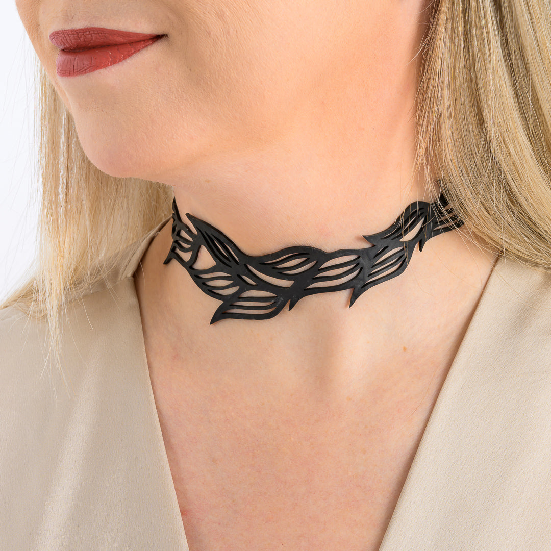 Paguro Upcycle black recycled rubber choker necklace with leaf pattern worn by a woman