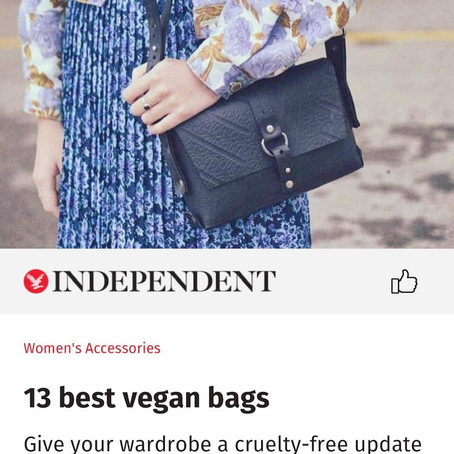 Black vegan handbag by Paguro Upcycle shown worn with floral blouse and blue patterned skirt