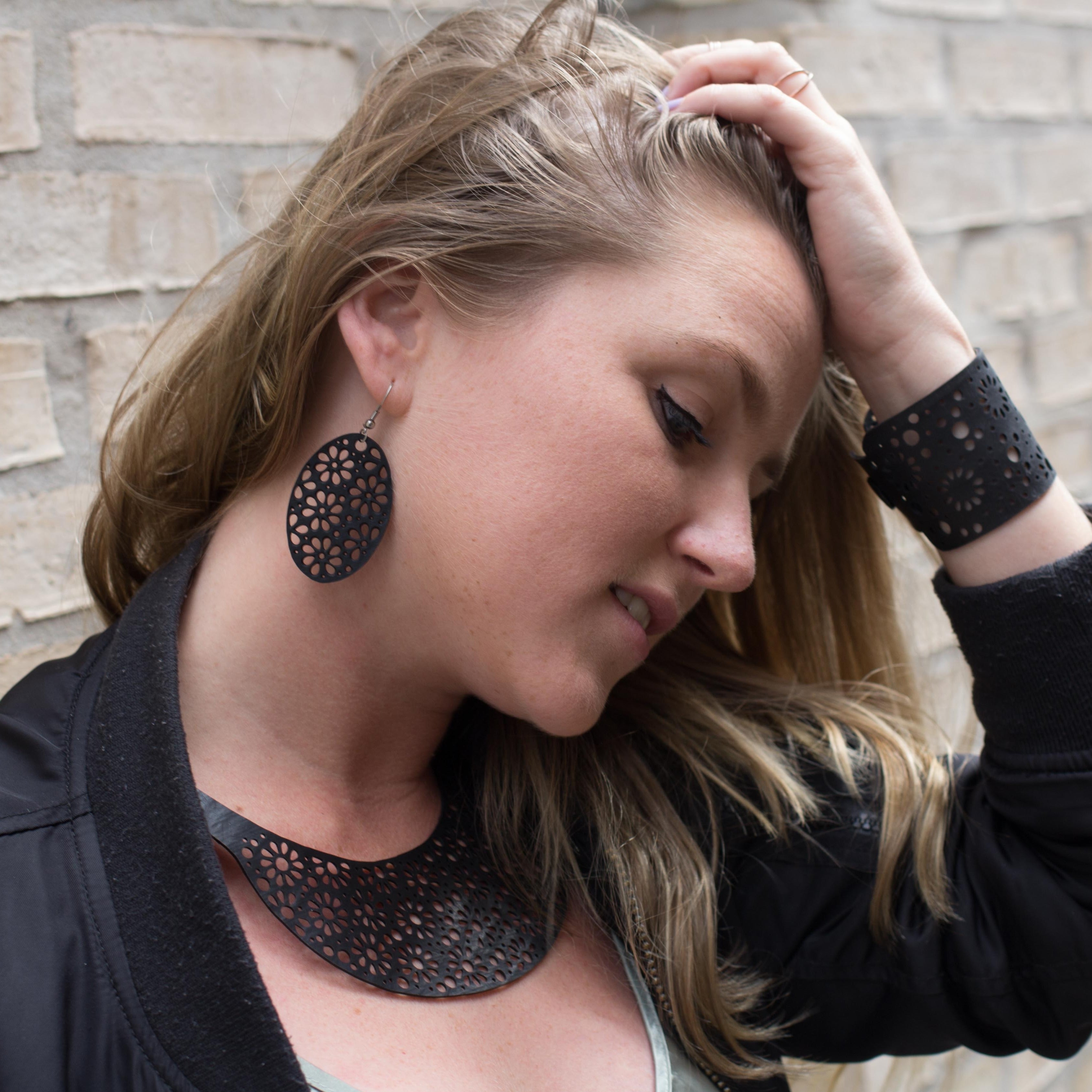 Paguro Upcycle model wearing black laser cut recycled rubber earrings UK with matching necklace and cuff