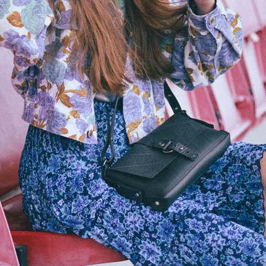 Paguro Upcycle recycle rubber vegan handbag showcased with a floral outfit in a stylish setting