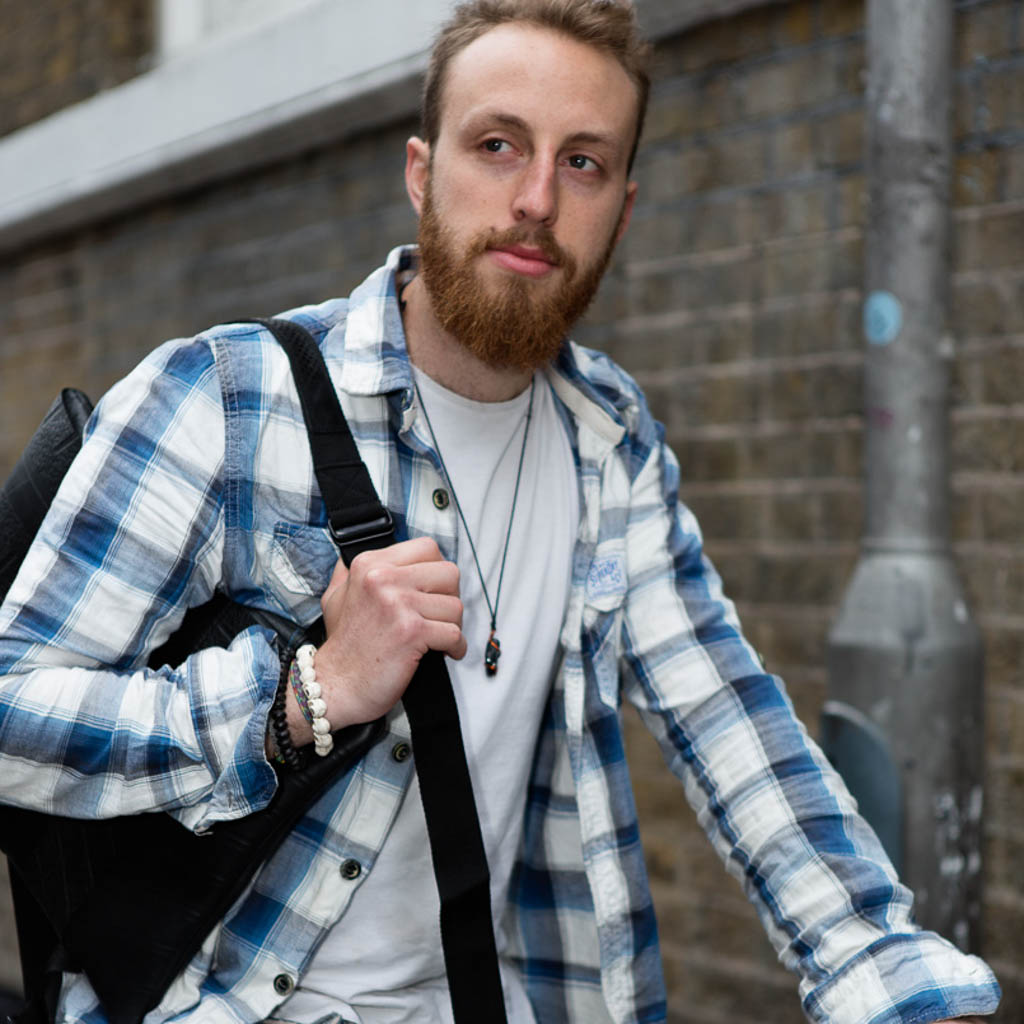 Man wearing a vegan inner tube backpack by Paguro Upcycle on a city street in casual outfit