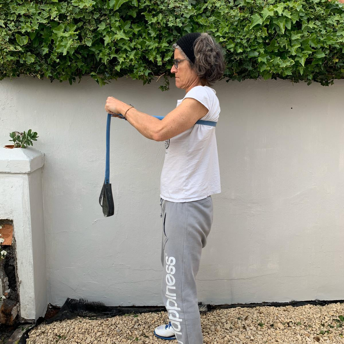 Woman using a Paguro Upcycle blue upcycled resistance band for exercise outdoors