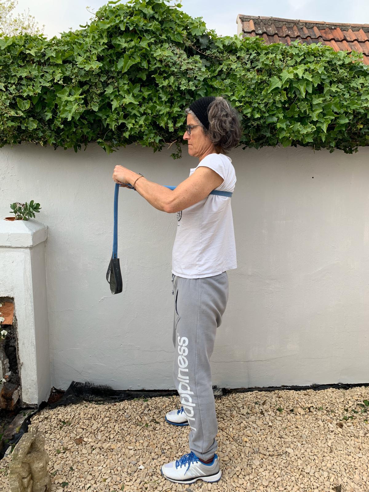 Woman using a Paguro Upcycle blue upcycled resistance band for exercise outdoors